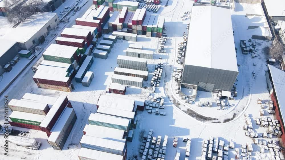 Shipping container and cargo crane at storage yard at winter time aerial view