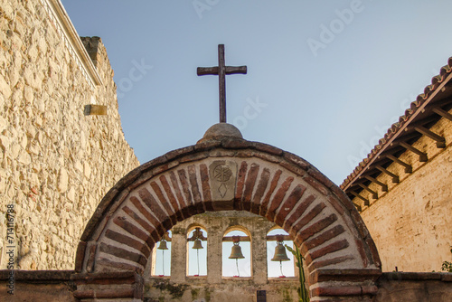 Wooden cross on top of an arch with bells