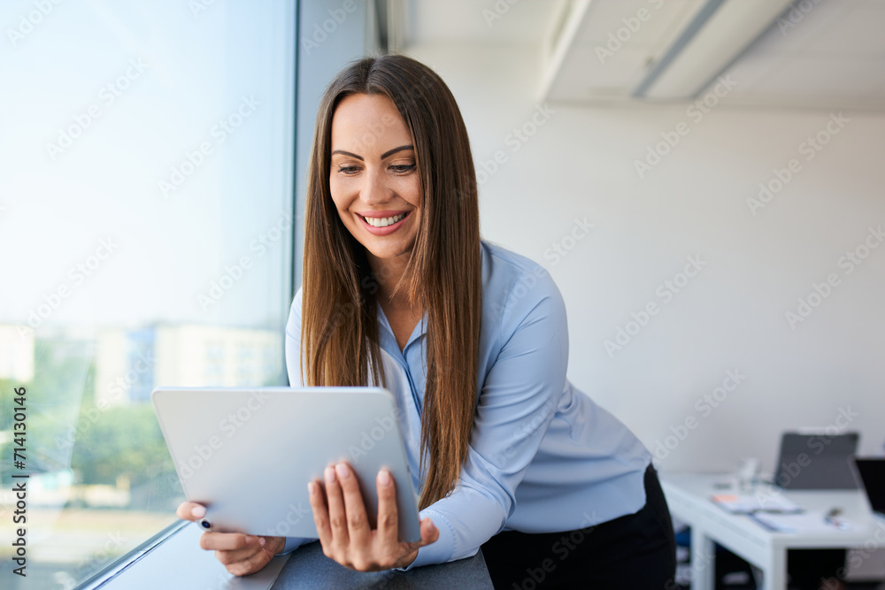 Attractive adult businesswoman using digital tablet at office Attractive adult businesswoman using digital tablet at office