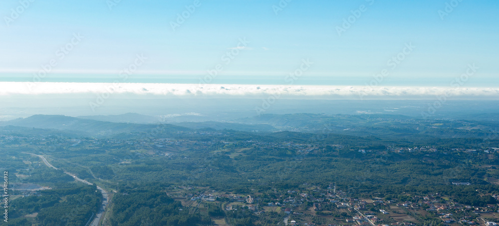 Aerial view of a natural park with ocean and clouds.