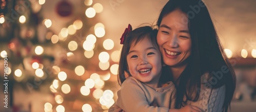 Happy Asian mother and daughter in cozy home at night.