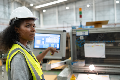 African American businesswoman working with use monitor control machine at Kraft paper factory 
