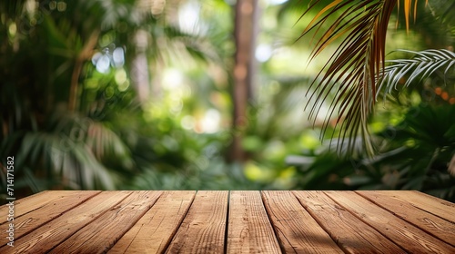 Empty wooden brown table top with blur background of palms garden