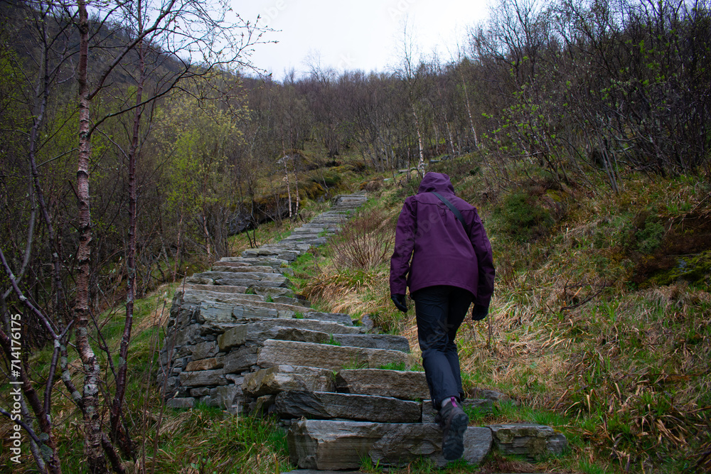 Female hiker climbing Old stone staircase once used by ancient monks. Reine, Lofoten, Norway