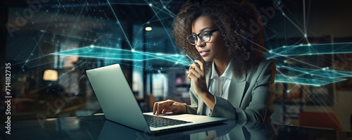 Woman with afro hair sltyle sitting and working with laptop in her office.