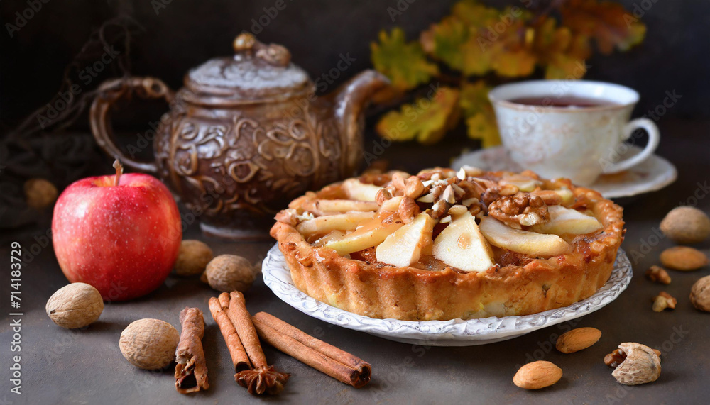 Apple pie with black tea and nuts in the background.