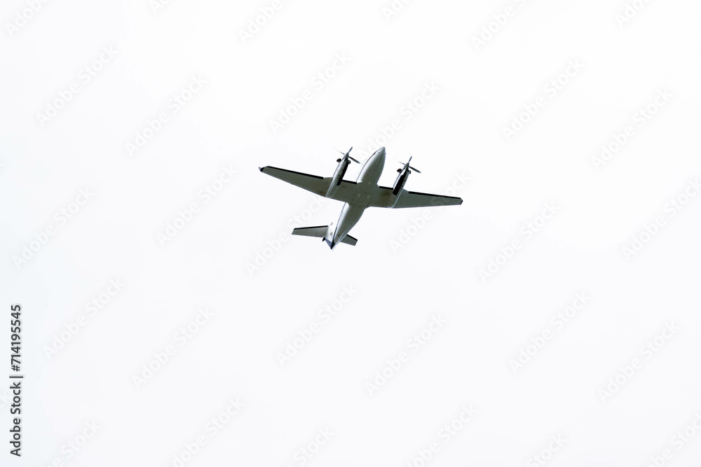 Silhouette of a twin-engine plane flying in a blue sky between clouds. Transportation. Aircraft. Silhouette of a twin-engine plane flying in a blue sky between clouds. Transportation. Aircraft.
