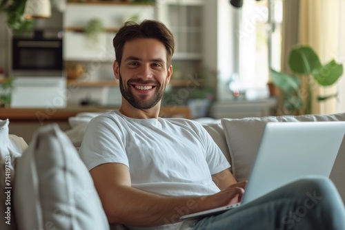 Smiling Man Using Laptop in Cozy Living Room