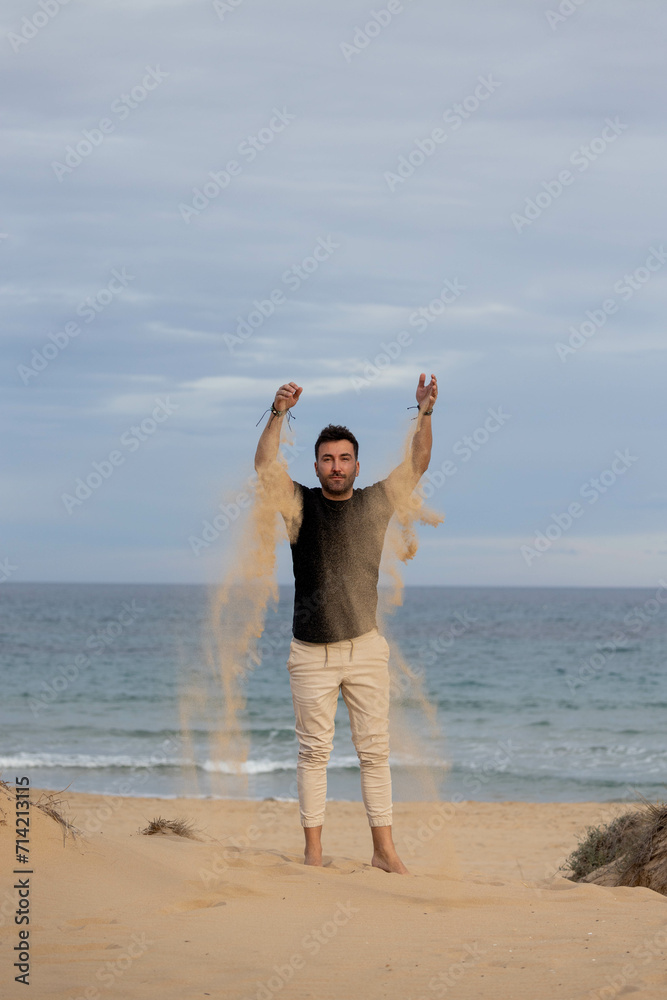 Barefoot man playing with sand on the beach Barefoot man playing with sand on the beach