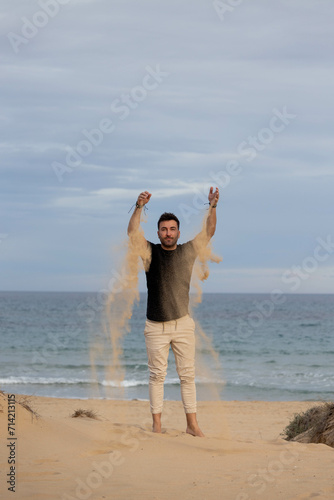 Barefoot man playing with sand on the beach
