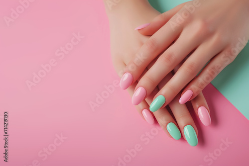Female hands showcasing pastel stylish trendy manicure against a mint and pink background