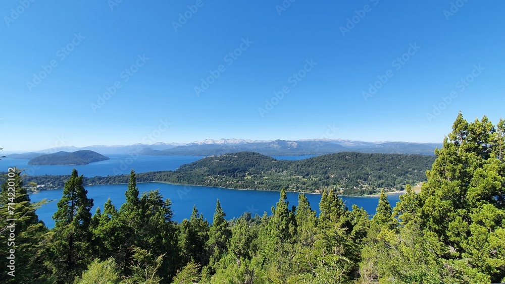 a lake and mountains with trees on top of it, including the water in front