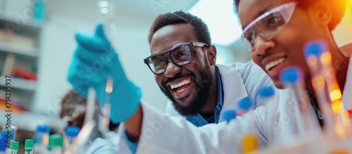 Joyful man and colleague happily pointing at test tube during successful research.