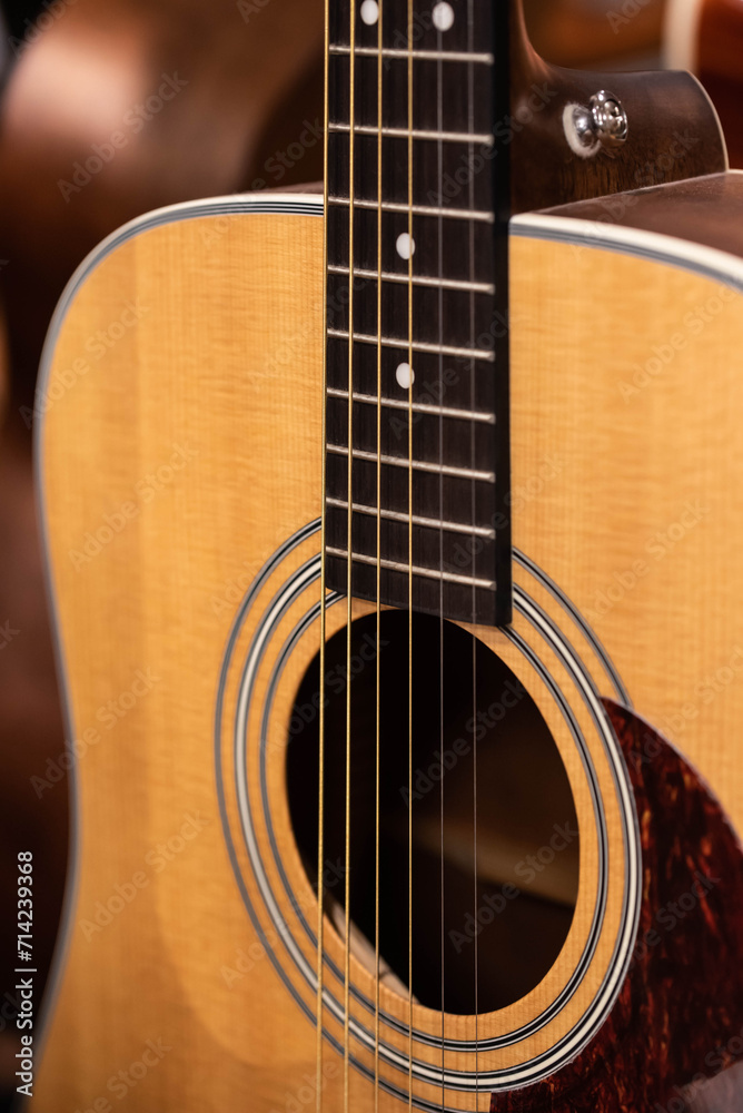 Closeup of row of different colorful guitars on the display for sale hanging in a music shop 