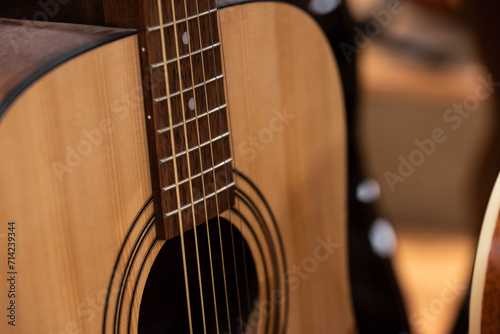 Closeup of row of different colorful guitars on the display for sale hanging in a music shop 