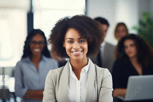 Photo of young office worker woman smiling at camera in front of people in suits