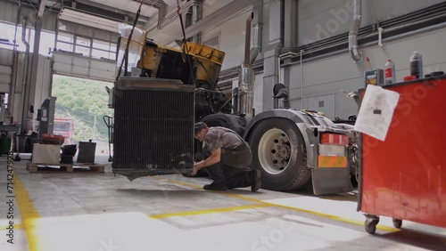 Auto mechanic repairs a huge truck truck radiator 