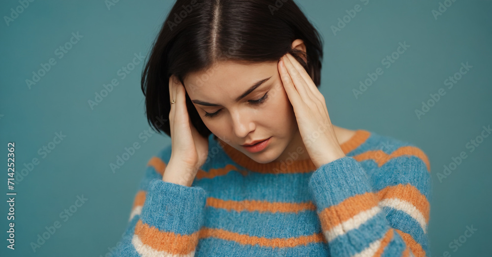 A portrait of a stylish and attractive young woman in a blue sweater, expressing shock and disappointment. A portrait of a stylish and attractive young woman in a blue sweater, expressing shock and disappointment.