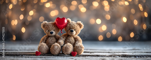 Two teddy bears with a red heart shaped balloon on blurred background with golden lights. Cute bear couple toy hugging and holding heart. Valentine's day. Love and romantic concept