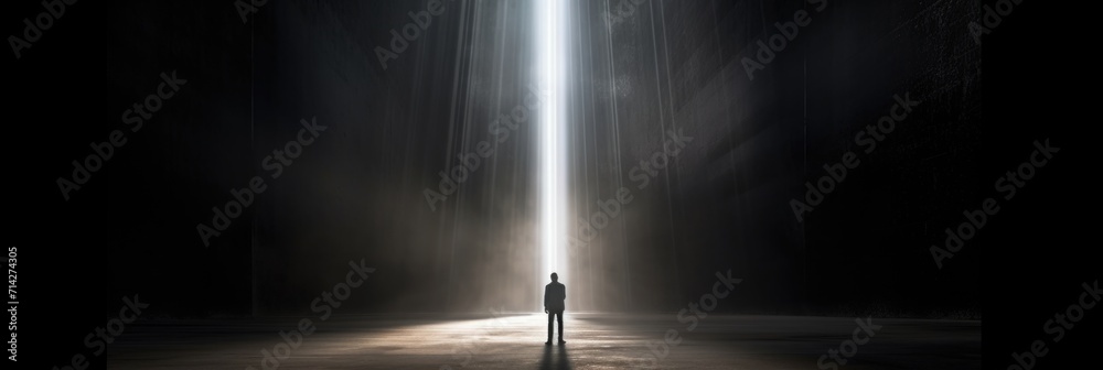 man is standing around the opening of an empty dark room 