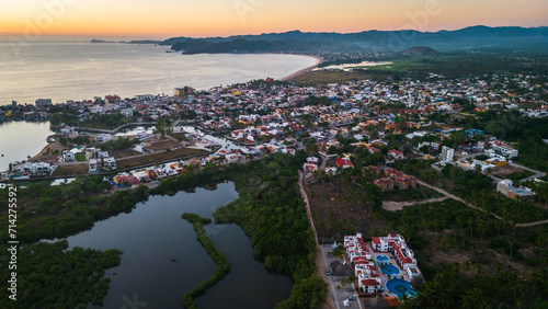 Barra de Navidad Aerial of Jalisco Mexico resort beach town with pacific coastline ocean view at sunset and lake lagoon