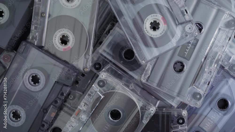 A stack of audio tape cassettes spinning on black background. Retro vintage music concept. A stack of audio tape cassettes spinning on black background. Retro vintage music concept.