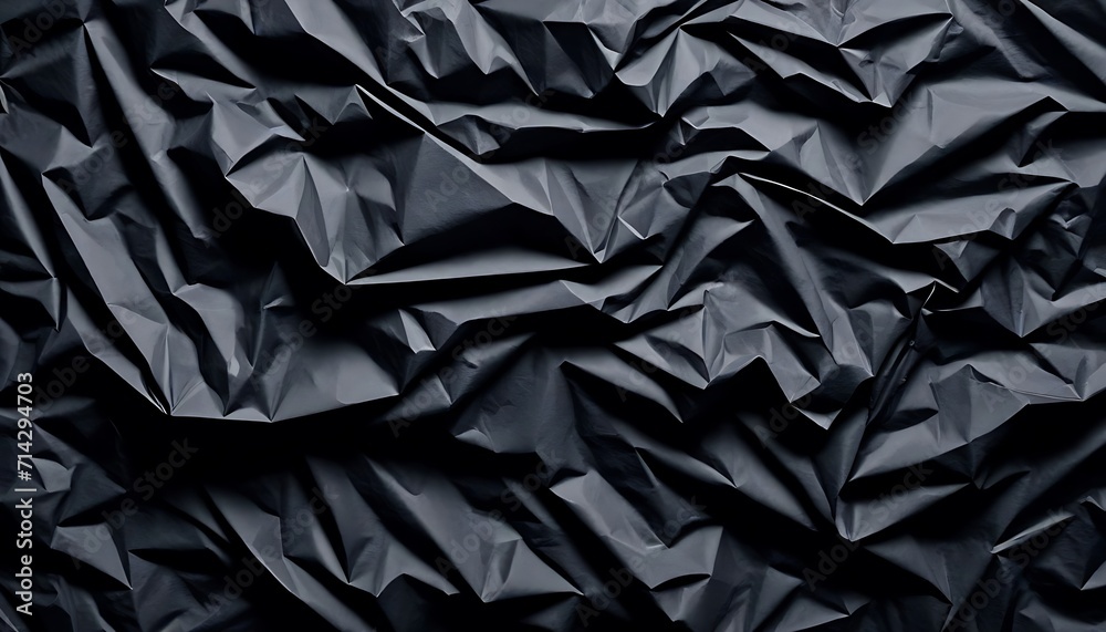Black crumpled paper texture in low light background Black crumpled paper texture in low light background