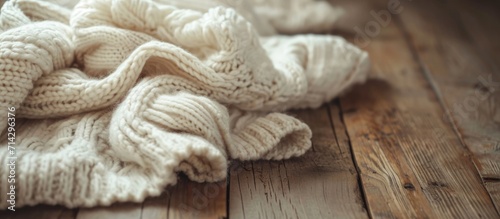 Retro-style image of white knitted sweaters on a wooden table.