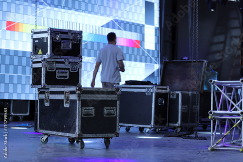 Technicians working setting up a stage with giant LED screens. Drawers for carrying equipment for shows and setting up stages. Trunks for technical equipment for events.  Technical setup of stage.