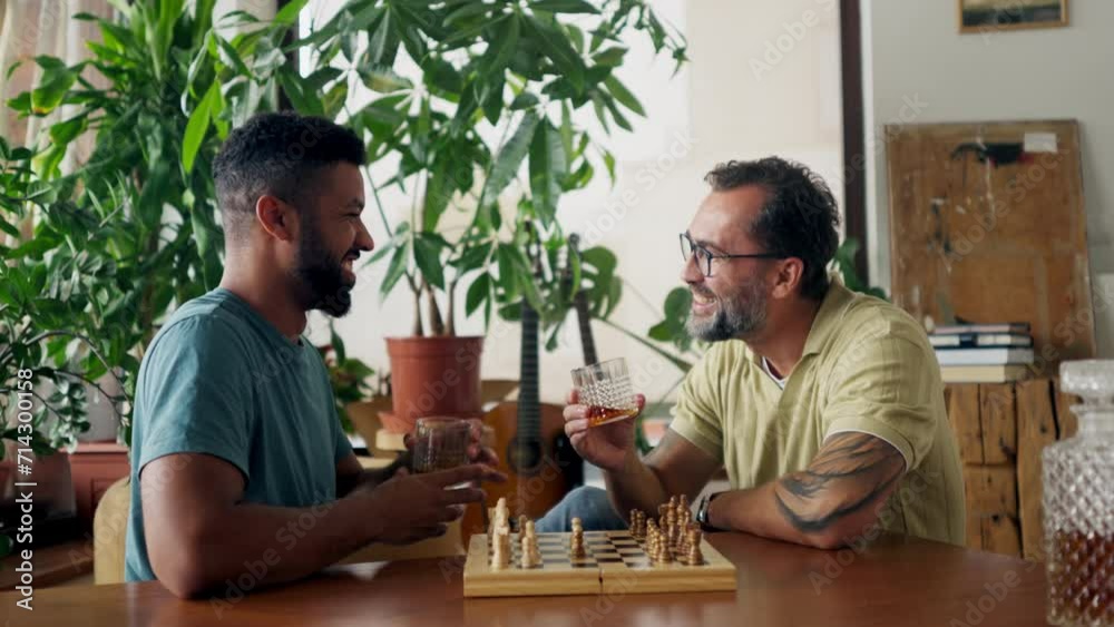 Best friends playing chess together, drinking whiskey and talking. Concept of male friendship, bromance.