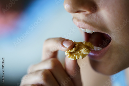 Unrecognizable girl with mouth open about to eat healthy walnut © javiindy