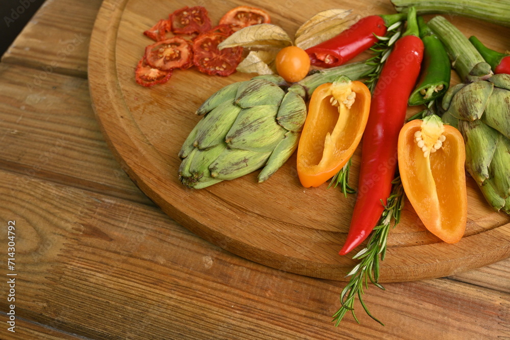 Overhead view of fresh and raw artichoke on the wooden table, vegetable composition bitter pepper, yellow pepper free place for text Overhead view of fresh and raw artichoke on the wooden table, vegetable composition bitter pepper, yellow pepper free place for text