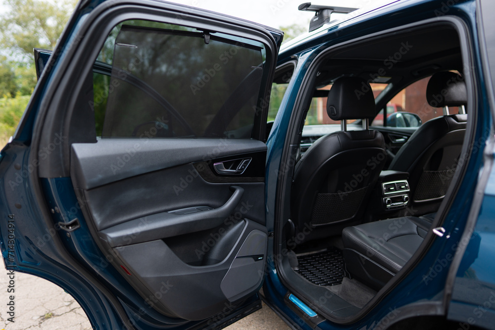 Rear passenger's door of luxury automobile being opened while vehicle being parked in urban area. Clear lines and stylish design of modern car Rear passenger's door of luxury automobile being opened while vehicle being parked in urban area. Clear lines and stylish design of modern car