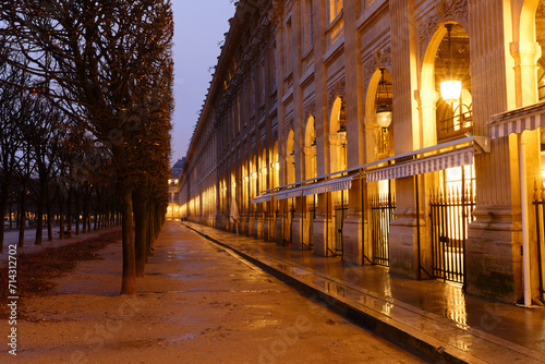 The wall of arches, columns and arcades bordering the Royal Palace Garden at rainy night. Paris. France. photo