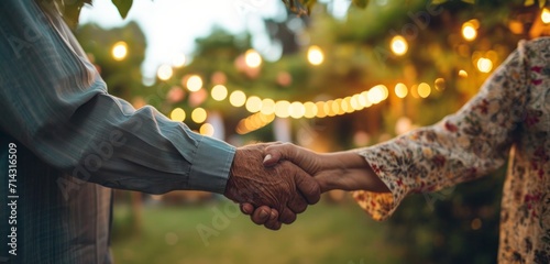 a senior couple is holding hands while at a yard party