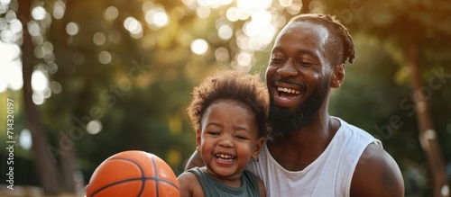 Happy African-American man with child and basketball © 2rogan