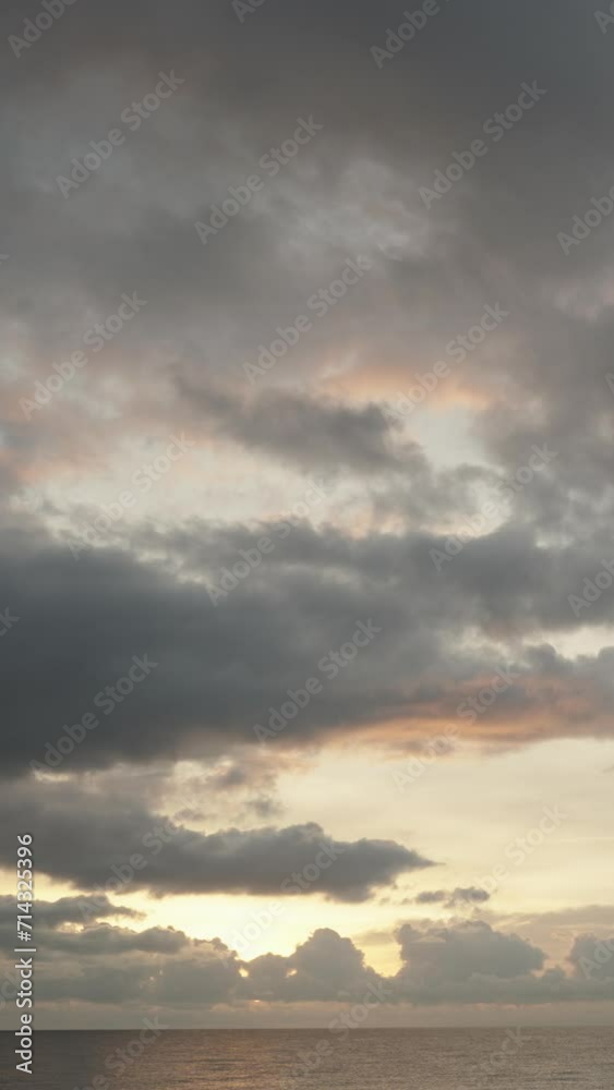 Vertical video. An island in the sea against the backdrop of clouds and the setting sun behind them. Vertical video. An island in the sea against the backdrop of clouds and the setting sun behind them.