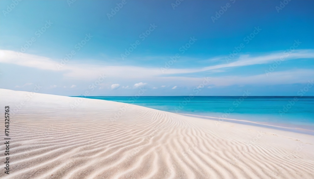 white sand curve or tropical sandy beach with blurry blue ocean and blue sky background image for nature background or summer background