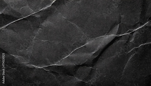 crumpled black paper with a detailed texture close up the paper with white cracks rough paper texture for background photo