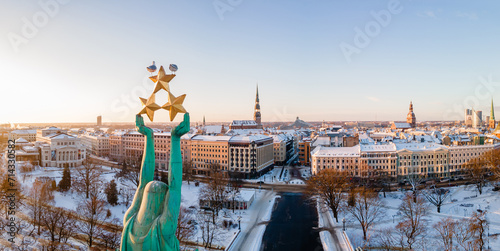 Beautiful sunrise panorama  over Riga by the statue of liberty - Milda in Latvia. The monument of freedom. photo