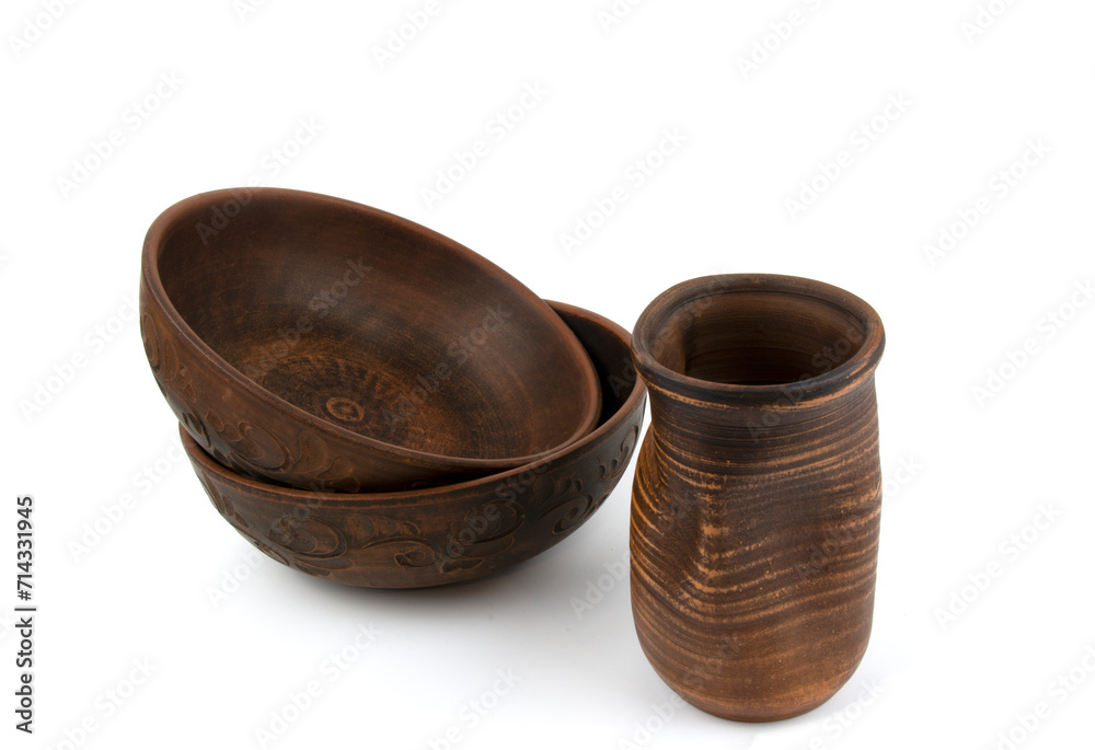 Two deep handmade clay plates and a close-up drink bowl. Isolated objects on a white background. Side view. Kitchen utensils, dishes for food Two deep handmade clay plates and a close-up drink bowl. Isolated objects on a white background. Side view. Kitchen utensils, dishes for food