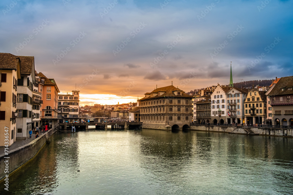Zurich city center, Switzerland. Zuerich old town with Town Hall and Rathaus bridge on bank of river Limmat at sunset with dramatic sky in winter