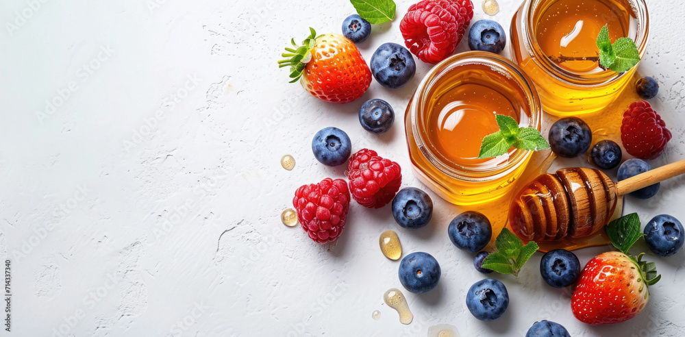 Organic honey and fresh berries setup on a white background, illustrating natural sweeteners and antioxidants