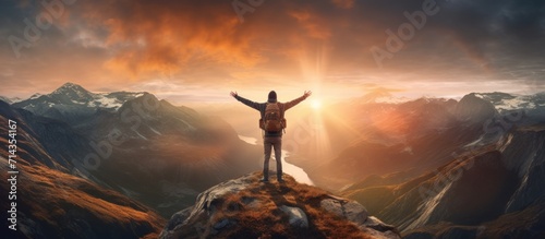 A young man hiker with his arms outstretched stands freedom on a top of mountain. Generate AI