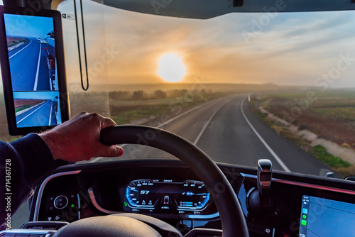 View from the driver's seat of a truck with camera rearview mirrors of a conventional road at dawn, interior of the vehicle. photo