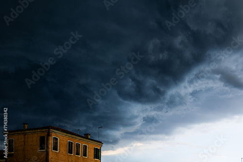 Dark textured and voluminous clouds before rain. Dark clouds and building