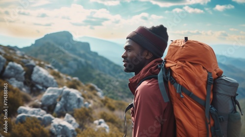 Happy young african american man hiking in the mountains.