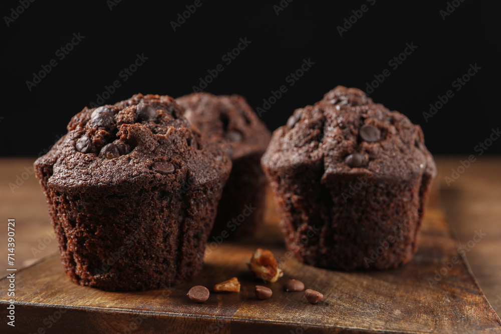 Delicious chocolate muffins on wooden table, closeup Delicious chocolate muffins on wooden table, closeup
