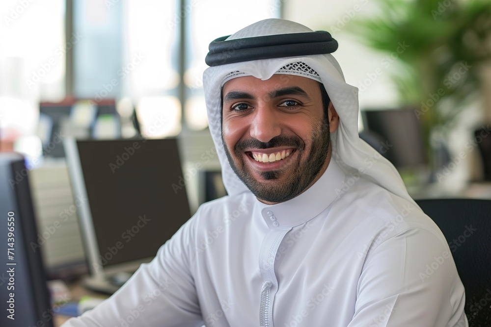 smiling emirati arab at office wearing kandura