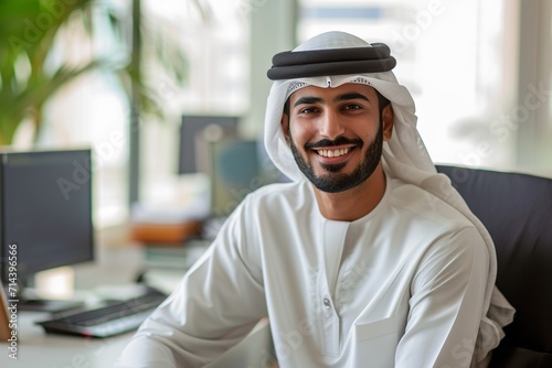 smiling emirati arab at office wearing kandura photo
